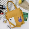 Canvas Student Tote with Rabbit Graphic and Front Pockets Yellow color SKU reference