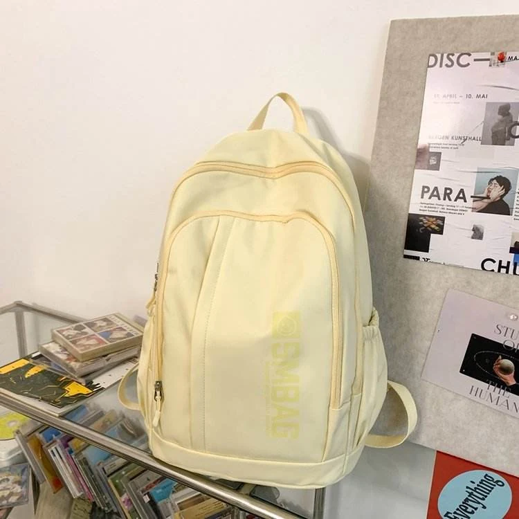Nylon Student and Travel Backpack with Decorative Doll Charm Yellow color SKU reference